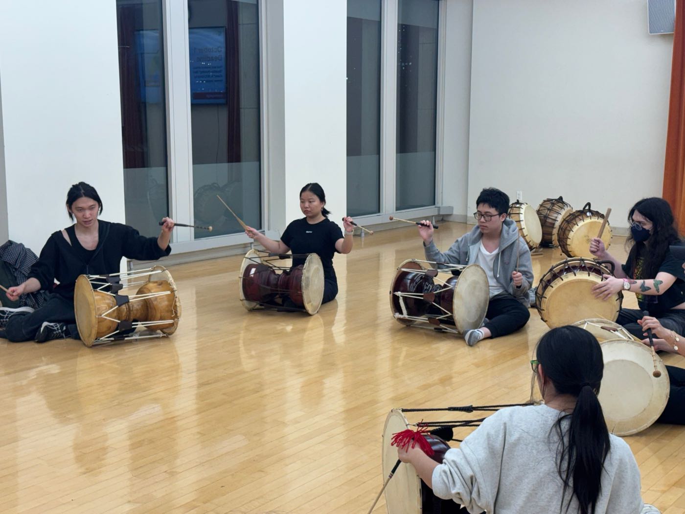 Janggu and buk players mid-stroke during rehearsal